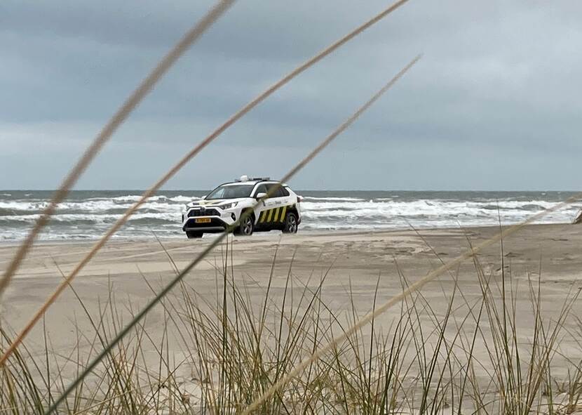 een Douane-auto rijdt over het strand